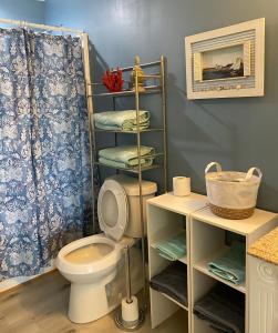ein Badezimmer mit einem WC und einem Regal mit Handtüchern in der Unterkunft J & H's Bayou Bliss in Shoreline Park