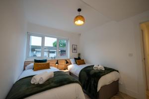 dwa łóżka w pokoju z oknem w obiekcie Exquisite 6 Bedroom Luxury Home Manchester w Manchesterze