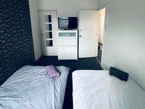 a small room with two beds and a microwave at Spacious 4 Bedrooms, 3 Bathrooms, Sleeps 8 in Coventry