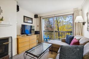 a living room with a couch and a tv at Ski home to this cozy one bedroom condo Whiffletree F5 in Killington