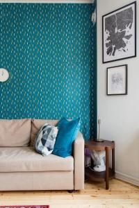uma sala de estar com um sofá com almofadas azuis em Renovated Design District Studio em Helsinque