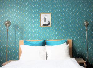 a bedroom with a bed and a wall with green wallpaper at Renovated Design District Studio in Helsinki