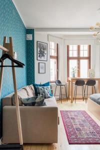uma sala de estar com um sofá e uma mesa em Renovated Design District Studio em Helsinque