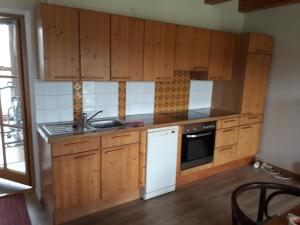 een keuken met houten kasten en een witte vaatwasser bij Ruhe und Entspannung in Amesedt