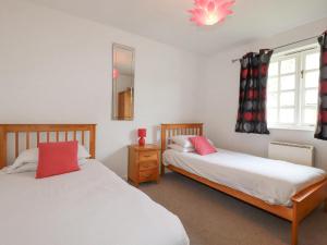 a bedroom with two beds and a window at Bracken Cottage in Bodmin