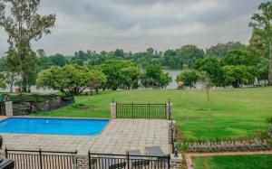 a backyard with a swimming pool and a field with trees at PontVineyard @ Pont de Val in Parys