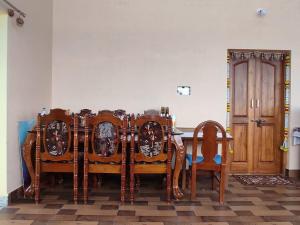 comedor con mesa y sillas de madera en Vrindavan, en Mysore
