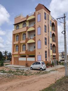 un coche aparcado frente a un edificio en Vrindavan, en Mysore