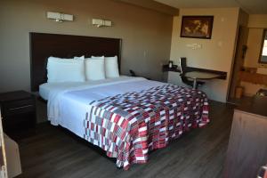 una camera d'albergo con un grande letto e un tavolo di Red Roof Inn Jackson North – Ridgeland a Ridgeland