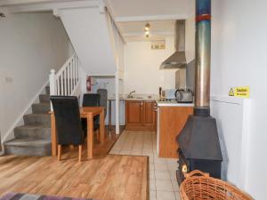 a kitchen and dining room with a wood stove at Nest Cottage in Bodmin