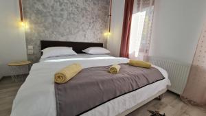 1 dormitorio con 1 cama grande y 2 toallas. en Pomiculturii Residence 2, en Timisoara