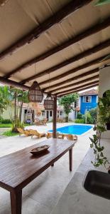 a patio with a wooden table and a pool at Pousada Varanda do Sol in Arraial d'Ajuda