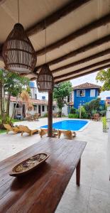 una mesa de madera en un patio con piscina en Pousada Varanda do Sol, en Arraial d'Ajuda