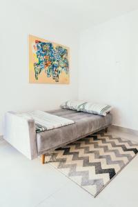 un letto in una stanza con un tappeto di Apartamentos modernos e aconchegantes no centro. a Poços de Caldas