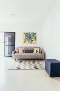 波蘇斯迪卡爾達斯的住宿－Apartamentos modernos e aconchegantes no centro.，带沙发和蓝色搁脚凳的客厅