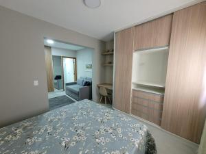 1 dormitorio con 1 cama y 1 sofá en una habitación en Apartamentos modernos e aconchegantes no centro. en Poços de Caldas