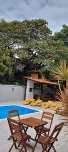 a group of chairs and a table next to a pool at Pousada Varanda do Sol in Arraial d'Ajuda