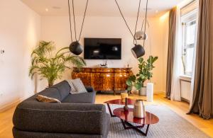 ein Wohnzimmer mit einem Sofa und einem TV in der Unterkunft Main Square Luxury Apartment View Central Residence Zagreb in Zagreb