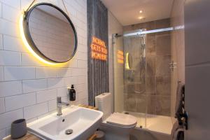 W łazience znajduje się umywalka, toaleta i lustro. w obiekcie higgihaus Apartment 3 Clare Street Aparthotel Central Location w Bristolu