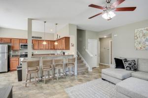 a living room with a couch and a kitchen at Lovely Lawrence Home - 3 Blocks to KU! in Lawrence