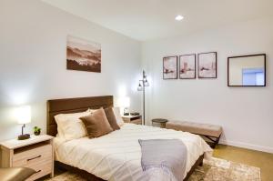 1 dormitorio blanco con 1 cama y 1 silla en Chic and Modern Snohomish Hideaway on a Working Farm, en Snohomish