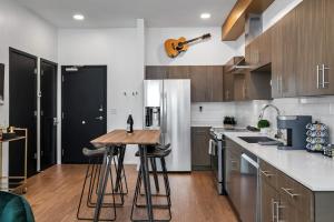 a kitchen with a wooden table and a refrigerator at UPSCALE Cozy Nashville Condo with POOL, PATIO, PARKING in Nashville