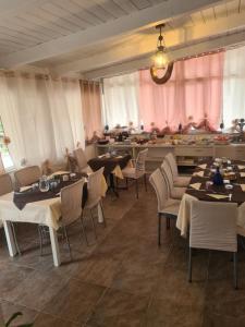 un restaurant avec des tables, des chaises et des rideaux roses dans l'établissement Agriturismo Cara Terra Lucana, à Chiaromonte
