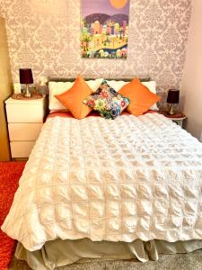 a bedroom with a large bed with orange pillows at Home from Home in our Self-Contained Annexe in Radwinter