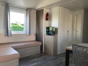 a small living room with a window and a television at La Côte d Opale - Le Portel - Vue sur mer - P31 - climatisé-2018 in Le Portel