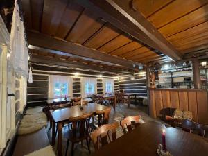 a restaurant with wooden tables and chairs in a room at Chalupa Hejmovka in Špindlerův Mlýn