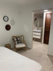 um quarto com uma cama, um espelho e uma cadeira em Piscadera Bay Resort #16 em Dorp Sint Michiel