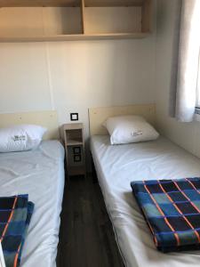 two beds in a room with white sheets and a pillow at La Côte d Opale - Le Portel - Vue sur mer - P31 - climatisé-2018 in Le Portel