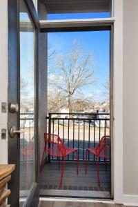 a balcony with two red chairs and a view of the water at Lovely 2 Bedroom,3 Bed Near Restaurants, Bars, Shopping and Vanderbilt, Belmont in Nashville