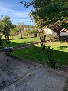 a grill sitting in a yard next to a park at Maison familiale 80m2 3 chambres 