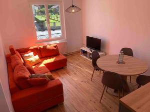 a living room with a couch and a table at Maison familiale 80m2 3 chambres in Naucelles