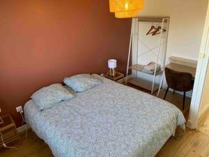 a bedroom with a bed with a blue comforter at Maison familiale 80m2 3 chambres in Naucelles