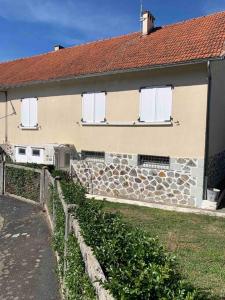 una casa con una recinzione di pietra di fronte di Maison familiale 80m2 3 chambres 