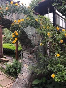 einen Steinbogen mit gelben Blumen, die darauf wachsen in der Unterkunft Home-restaurant in Vanadzor in Wanadsor