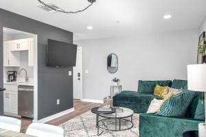 a living room with a green couch and a table at Walk to Downtown Broadway with Pool, Free Parking, and Gym in Nashville