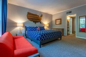 um quarto com uma cama azul e um sofá vermelho em Famous MUSIC ROW 1 Bedroom Condo with FREE Parking and Pool em Nashville
