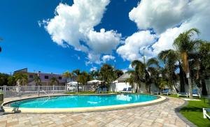 a swimming pool in a yard with palm trees at 2q Suite Apt W Shared Pool - 08 in Clearwater