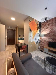 a living room with a couch and a brick wall at BoleslaviaApartments - Apartament Simon 2, Center, air conditioning in Bolesławiec