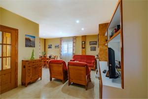 a living room with a red couch and a television at Pregonero House in Granada