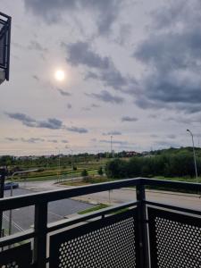 a view from a balcony of a street with the sun in the sky at Apartments in - Świergotki in Szczecin