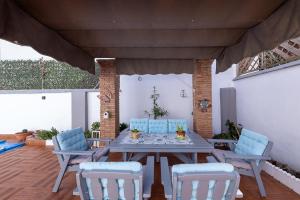 um pátio com uma mesa e cadeiras num deque em Pregonero House em Granada