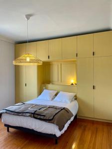 - une chambre avec un grand lit et un lustre dans l'établissement Appartement neuf style Art Déco au Bouscat, à Le Bouscat