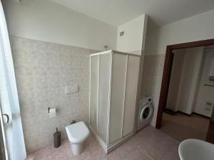 a bathroom with a toilet and a washing machine at AleGio Home in Zelo Buon Persico