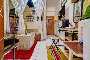 een woonkamer met witte gordijnen en een tafel bij OYO Life 93120 Apartement Gateway Cicadas By Sarana Cipta Mahakarya in Bandung