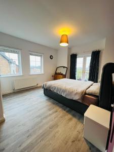 a bedroom with a large bed and two windows at A Perfect homestay near Belfast in Ballyclare