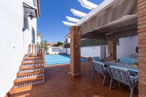 a patio with a table and chairs and a pool at Pregonero House in Granada